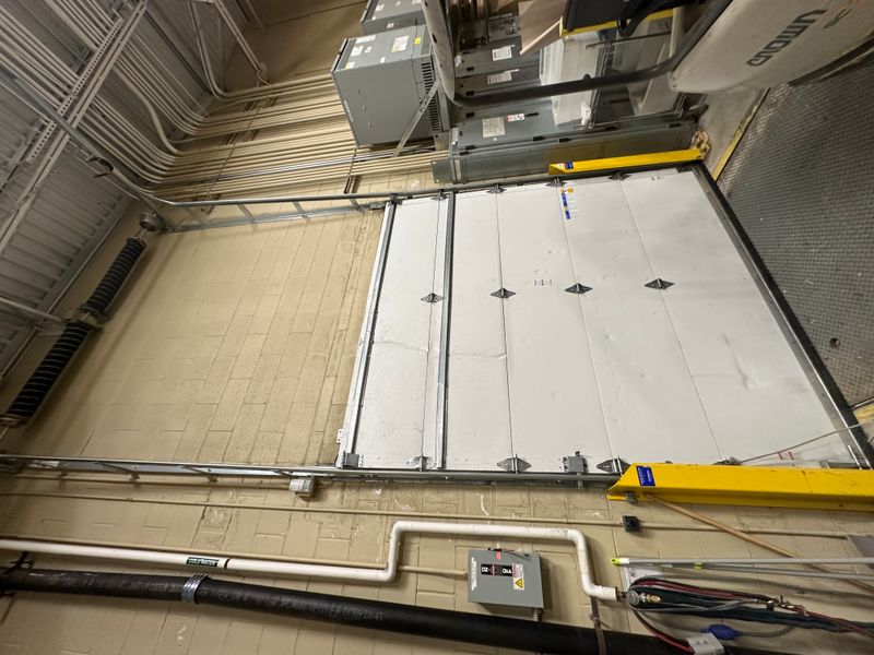 Large commercial sectional door with dual overhead openers and track system